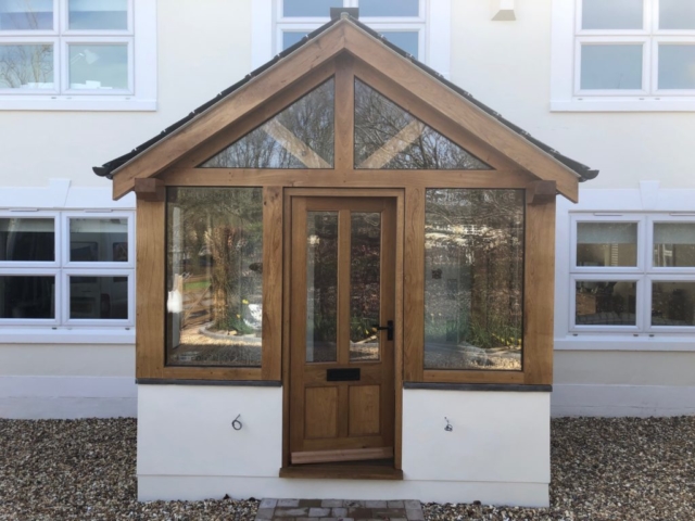 Enclosed oak porch with double glazed units and a slate roof