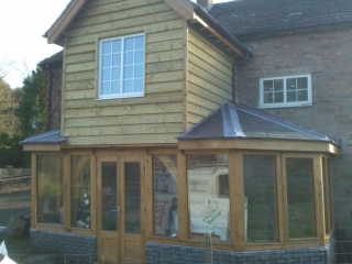 Glazed oak extension with two storey middle bay