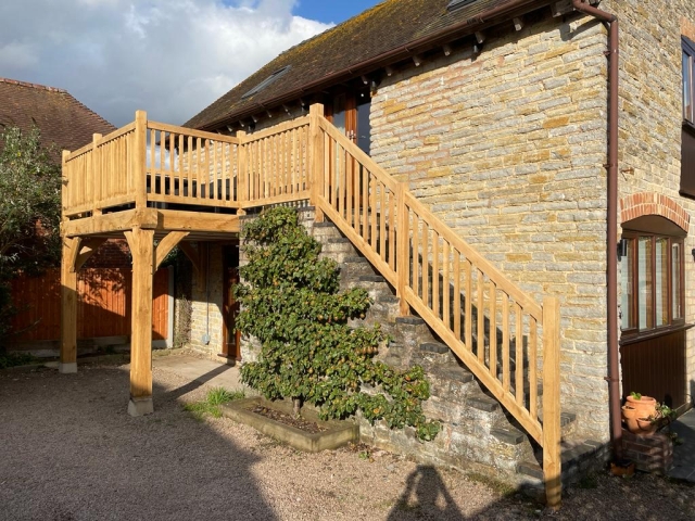 Oak framed balcony with oak balustrade fitted onto a stone barn