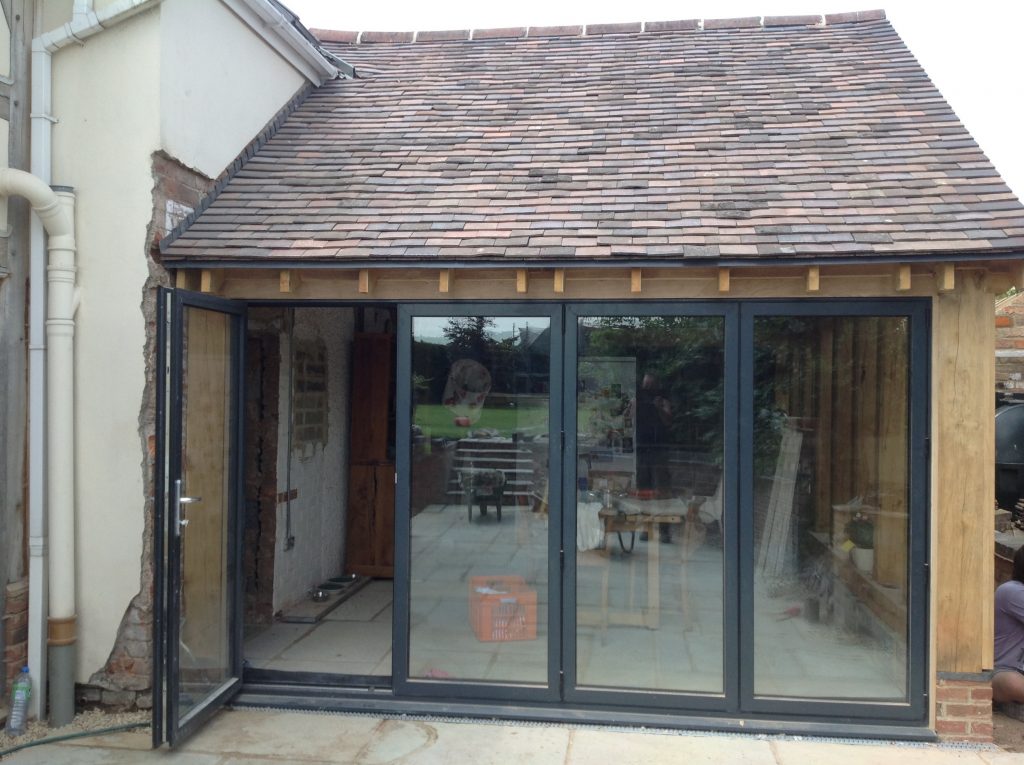 Oak framed extension with aluminium bi-folding doors