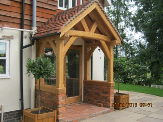 Oak porch with curved tie and braces sat on a brick wall