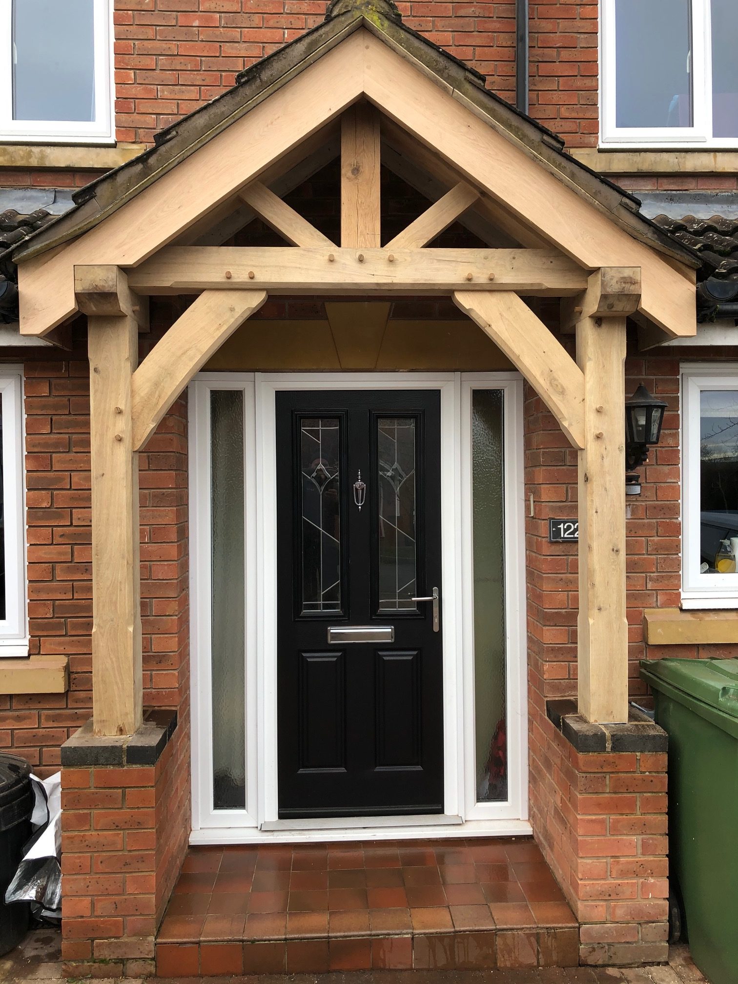 An oak porch fitted onto a modern red brick house.