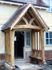 Oak framed porch with shaped tie beam and shaped front posts