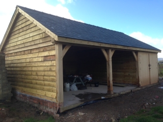 Triple bay oak framed garage with one bay enclosed