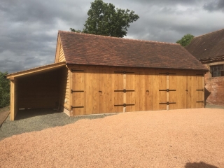 Triple bay oak framed garage enclosed with oak doors