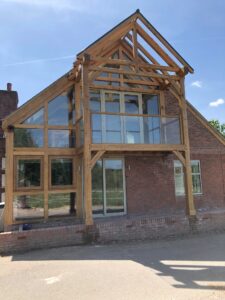 An oak framed extension with a glass balusrade balcony to the front.