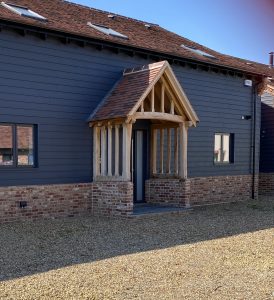 Oak Framed porch with brick wall and red tiled roof.