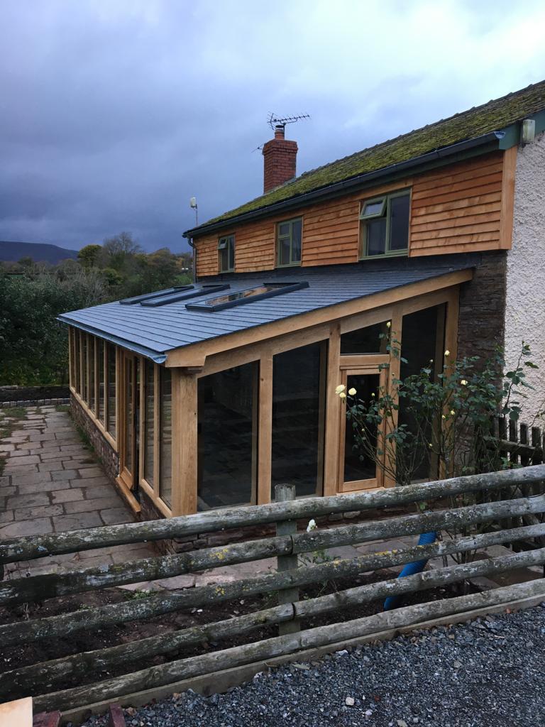 Oak Framed lean too extension fully glazed with oak french doors into the front.