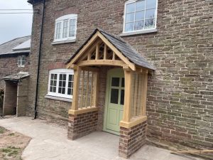 An oak framed porch sat on brick wall with a slate roof.